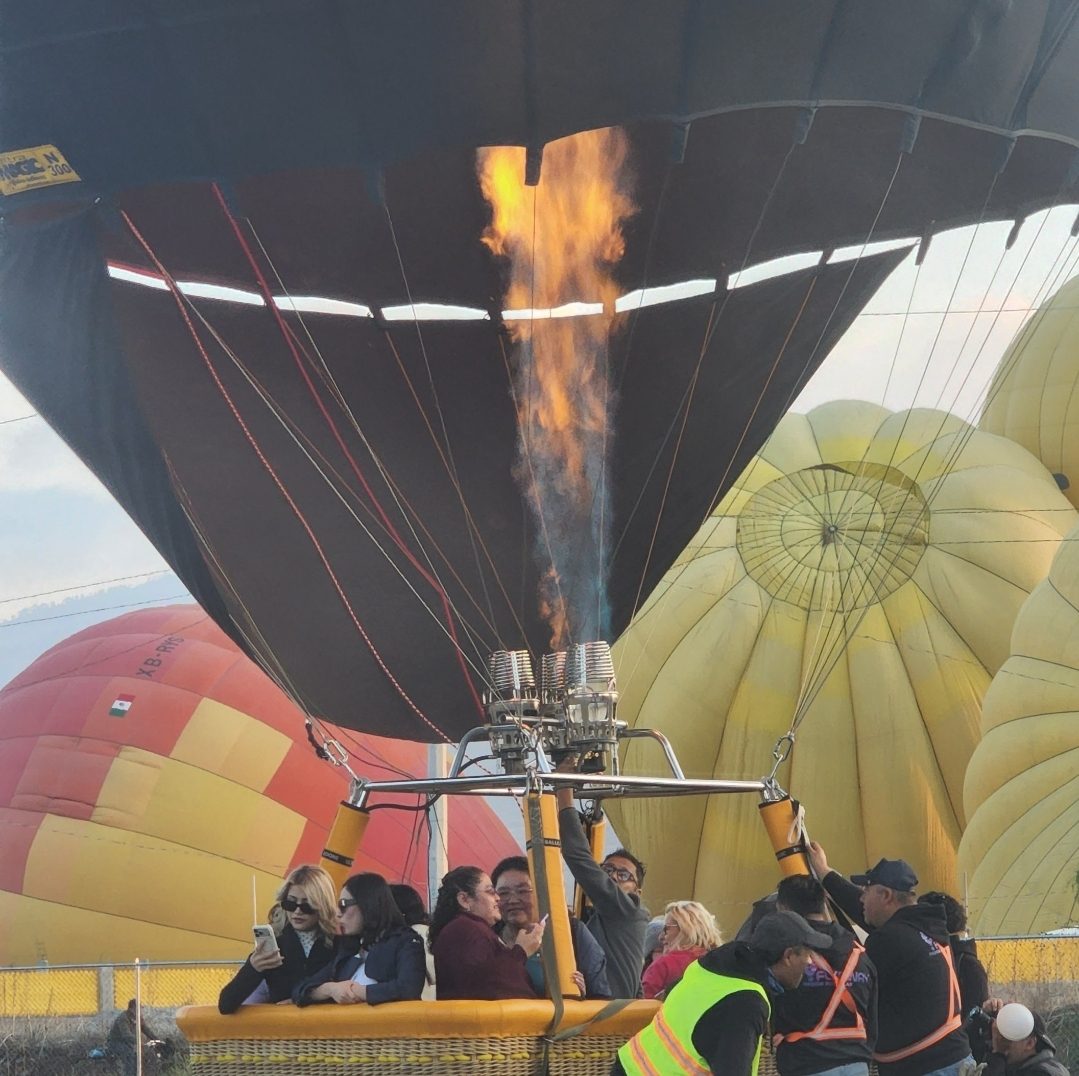 Passengers boarding a hot air balloon basket at dawn near Teotihuacan